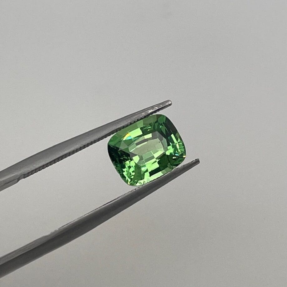 Tsavorite Garnet Cushion Cut loose in tweezers